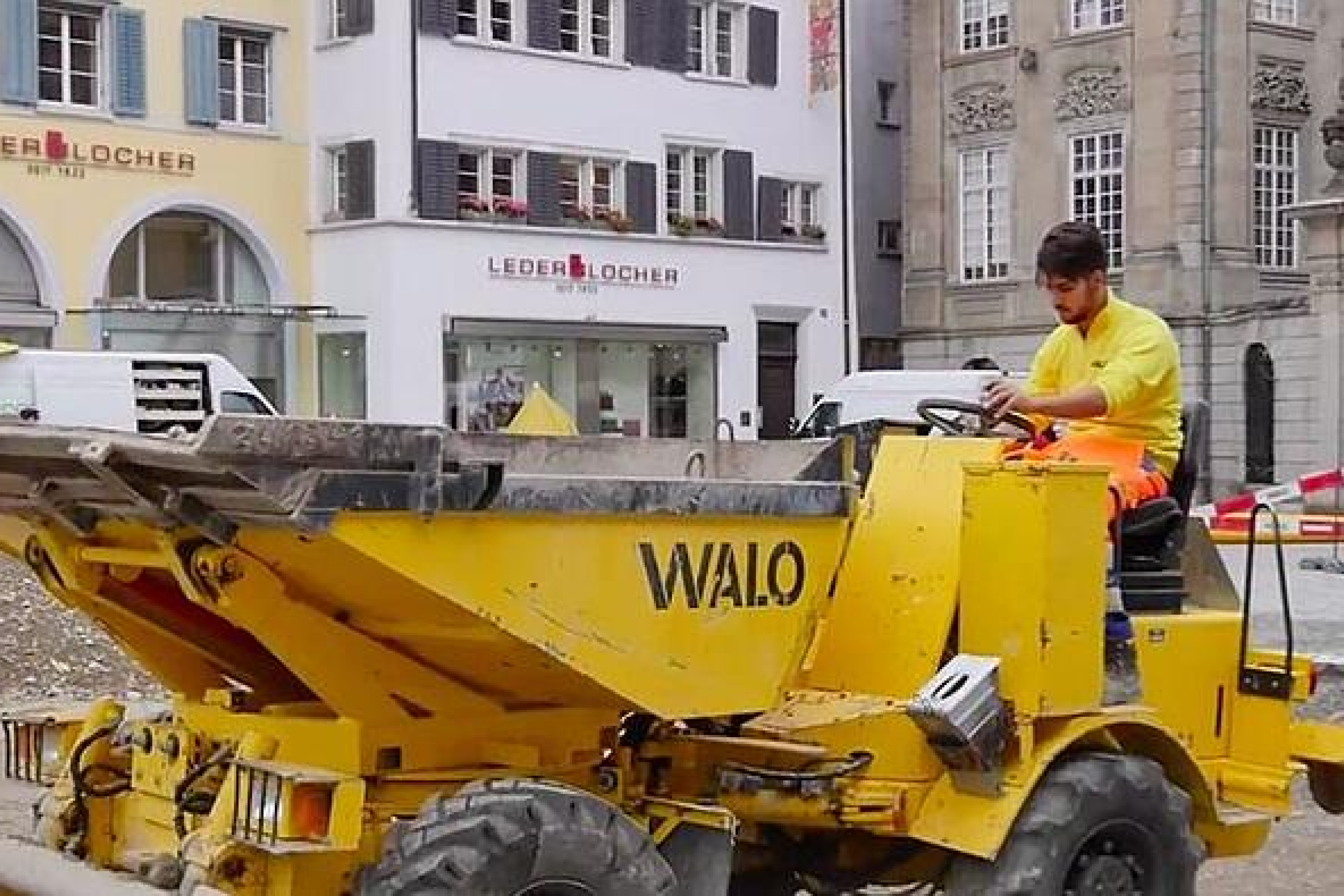 Person auf einem Gelben Lastenfahrzeug mit Aufschrift WALO