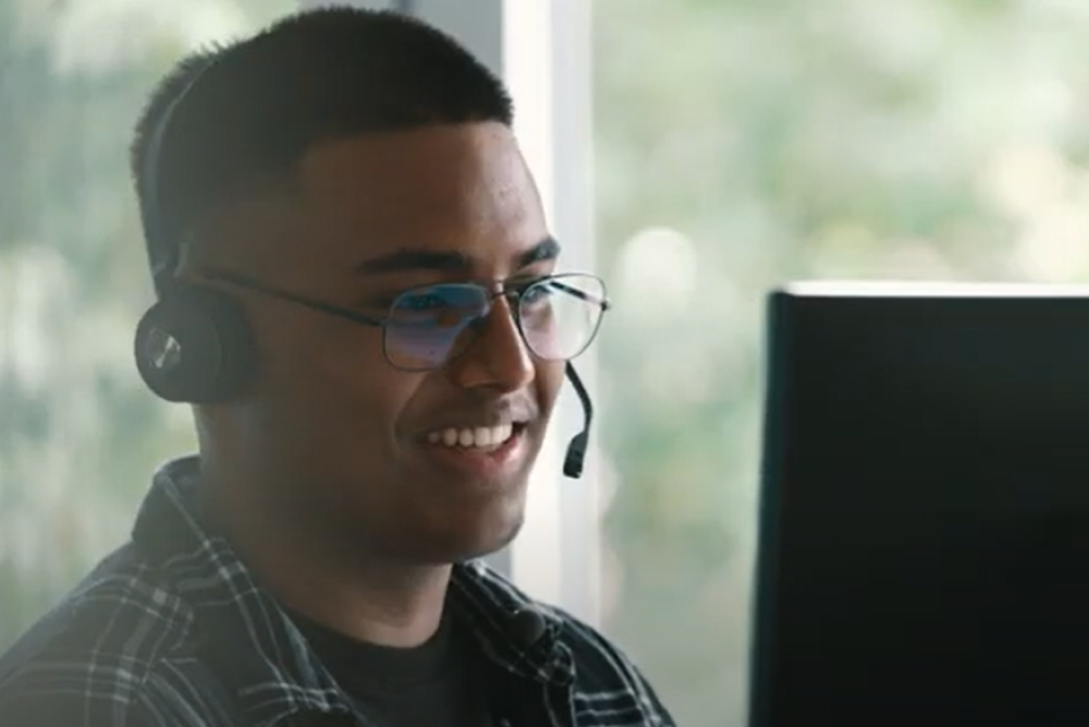 Junger Mann mit Headset am Computer